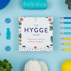 Conversation card game, family game night, party game, the Hygge Game, next to various items, hygge